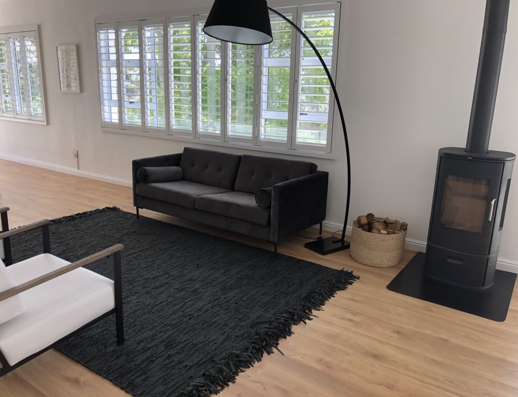 black rug on laminate floor dividing a areas space visually 